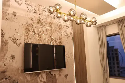 a chandelier hanging from a wall covered in dirt at The Royale Vista Burj Khalifa View Residence in Dubai