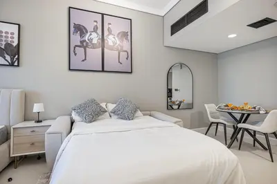 a white bedroom with a bed and a table at Luxury JLT Studio Lakeview Near Metro & Marina in Dubai