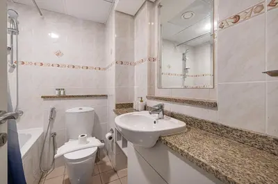 a white bathroom with a sink and a toilet at Luxury JLT Studio Lakeview Near Metro & Marina in Dubai