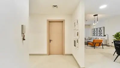 a hallway with a door and a living room at fam Living High Floor Stay in Sulafa Tower in Dubai