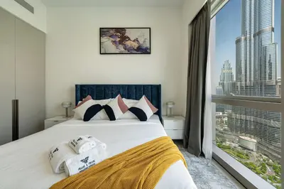 a bedroom with a bed and a large window at Stunning Full Burj Khalifa and Fountain View Apartment in Dubai