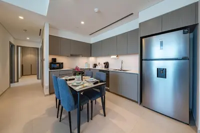 a kitchen with a table with chairs and a refrigerator at Stunning Full Burj Khalifa and Fountain View Apartment in Dubai