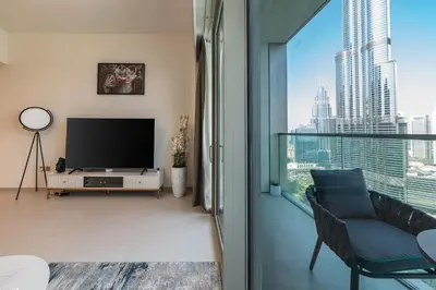 a living room with a tv and a large window at Stunning Full Burj Khalifa and Fountain View Apartment in Dubai