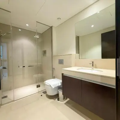 a bathroom with a shower and a toilet and a sink at Spacious Luxury Apartment Stunning Creek Views Family Friendly in Dubai