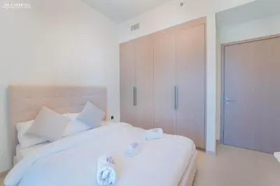 a bedroom with a large white bed and a door at Burj Khalifa - Fountain View - Astonishing Home in Dubai