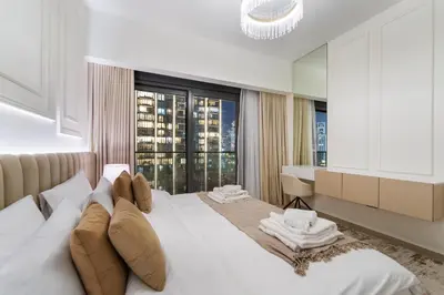 a bedroom with a white bed with a large window at Modern stylish 2BR Apartment walk to Dubai Mall near Burj Khalifa in Dubai
