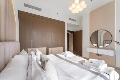 a large white bed in a room with a mirror at Modern stylish 2BR Apartment walk to Dubai Mall near Burj Khalifa in Dubai