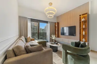 a living room with a couch and two chairs and a tv at Modern stylish 2BR Apartment walk to Dubai Mall near Burj Khalifa in Dubai
