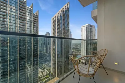 a balcony with chairs and a view of the city at Modern stylish 2BR Apartment walk to Dubai Mall near Burj Khalifa in Dubai