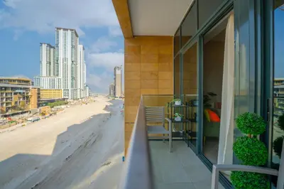 a balcony with a view of a beach and buildings at EasyGo - Elegant 1-Bedroom Apartment with Balcony in Dubai