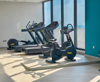 a row of exercise bikes in a gym with windows at EasyGo - Elegant 1-Bedroom Apartment with Balcony in Dubai