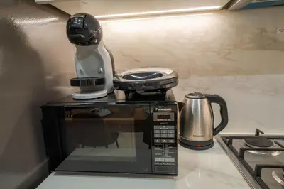 a coffee maker sitting on top of a microwave at EasyGo - Elegant 1-Bedroom Apartment with Balcony in Dubai