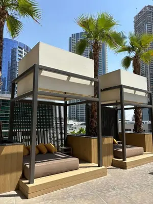 a canopy bed with palm trees in a city at Modern studio - Burj & canal view in Dubai