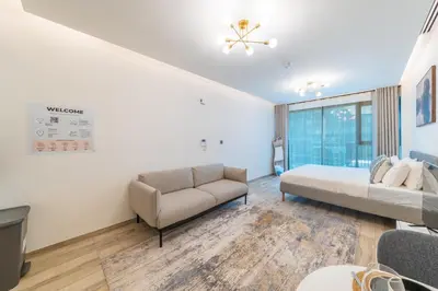 a living room with a couch and a bed at Modern studio - Burj & canal view in Dubai
