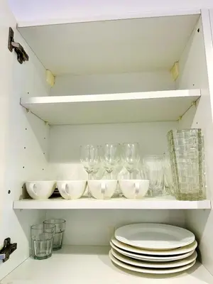 a shelf filled with glasses and plates in a kitchen at Palm Jumeirah Lifestyle - Elegant Waterfront Studio in Dubai