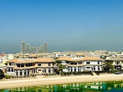 a group of houses on a beach with a city at Palm Jumeirah Lifestyle - Elegant Waterfront Studio in Dubai