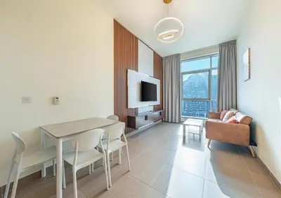 a living room with a dining room table and a couch at Luxurious apartment with Burj Khalifa & Canal Views in Dubai