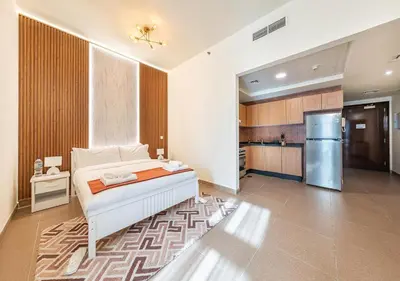 a bedroom with a bed and a refrigerator at Luxurious apartment with Burj Khalifa & Canal Views in Dubai