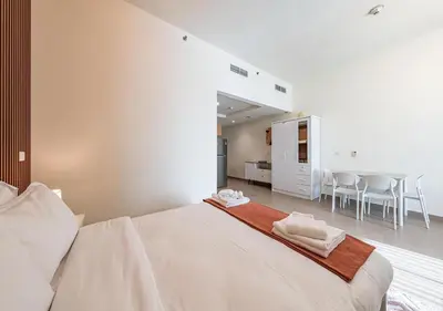 a white bedroom with a large bed and chairs at Luxurious apartment with Burj Khalifa & Canal Views in Dubai