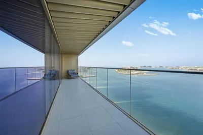 a view of the water from the balcony of a building at Luxury 2BR Emaar Beachfront with Private Beach & Infinity Pool, Palm Jumeirah & Atlantis Views in Dubai