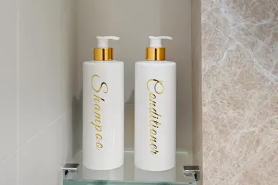 two white bottles ofodorizers sitting on a shelf at Luxury 2BR Emaar Beachfront with Private Beach & Infinity Pool, Palm Jumeirah & Atlantis Views in Dubai