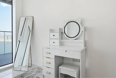 a white dressing table with a mirror and a mirror mirror dressing table with a mirror at Luxury 2BR Emaar Beachfront with Private Beach & Infinity Pool, Palm Jumeirah & Atlantis Views in Dubai