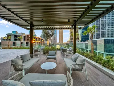 a rooftop patio with couches and tables and chairs at Artistic 2Bedroom with Skyline Khalifa View in Dubai