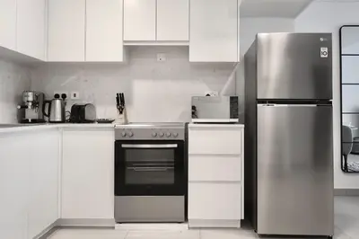 a kitchen with white cabinets and a stainless steel refrigerator at 1BR Madinat Jumeirah Living in Dubai