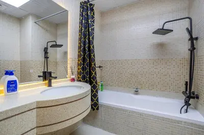 a bathroom with a tub with a shower and a sink at Luxury Condo 3 BR in Dubai Marina Sulafa 4004 in Dubai