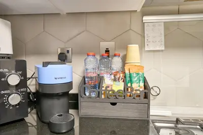 a kitchen counter with a coffee maker and bottles of water at Luxury 1BR Downtown Modern Urban Stay in Dubai