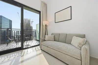 a living room with a couch and a balcony at Zada 1BR High Floor - Stunning View 1min Downtown and 2min to Metro in Dubai