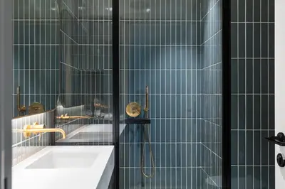 a bathroom with a tub and a shower with blue tiles at Executive Studio in Business Bay with Working Area, Pool, Gym in Dubai