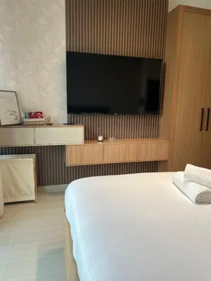 a bedroom with a bed and a flat screen tv at Elegant Studio Stay in Binghatti Tulip Dubai in Dubai