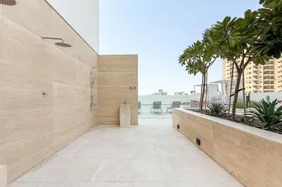 a hallway of a building with palm trees and a balcony at Elegant Studio Stay in Binghatti Tulip Dubai in Dubai