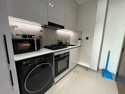 a kitchen with a stove and a microwave at Elegant Studio Stay in Binghatti Tulip Dubai in Dubai