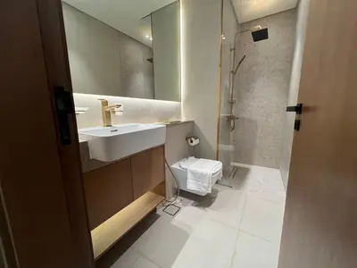 a bathroom with a sink and a toilet and a mirror at Elegant Studio Stay in Binghatti Tulip Dubai in Dubai