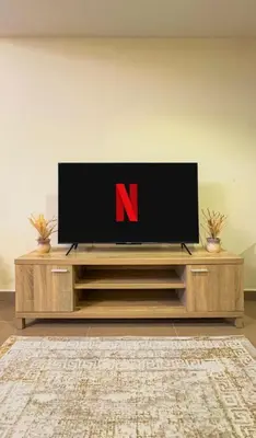 a flat screen tv sitting on top of a entertainment center at Stylish Dubai Stay in Dubai