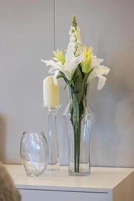 a glass vase with white flowers on a table at Skyline Views with Waterfront & Marina Walk - 3 BDR Apartment in Dubai