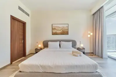 a bedroom with a large white bed and a window at fam Living Ultra Luxury 3BR Burj Khalifa View in Dubai