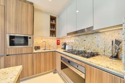 a kitchen with wooden cabinets and a counter top at fam Living Ultra Luxury 3BR Burj Khalifa View in Dubai