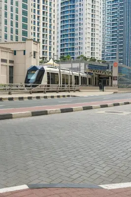 a train on a track in a city with tall buildings at Deluxe Ensuite Room with Balcony & Twin Beds in Dubai