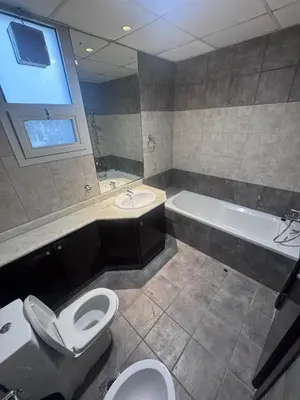 a bathroom with two toilets and a tub and a sink at Deluxe Ensuite Room with Balcony & Twin Beds in Dubai
