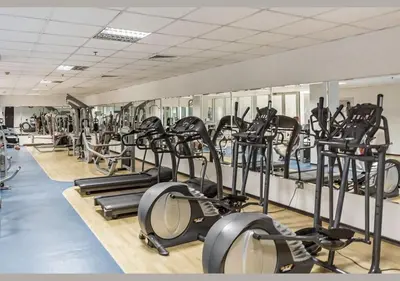 a gym with rows of treadmills and elliptical machines at Deluxe Ensuite Room with Balcony & Twin Beds in Dubai