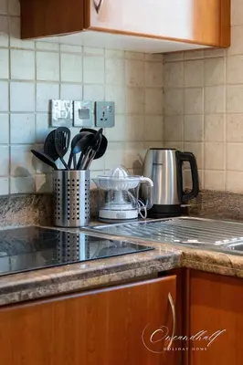a kitchen counter top with a stove top with a tea kettle at Cool 1BR with Balcony in Marina, Steps from Metro in Dubai