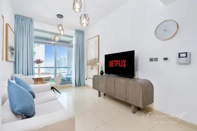 a living room with a tv and a couch at Cool 1BR with Balcony in Marina, Steps from Metro in Dubai