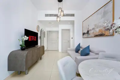 a living room with a couch and a table at Cool 1BR with Balcony in Marina, Steps from Metro in Dubai