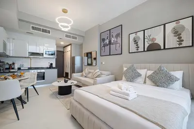 a bedroom with a large bed and a kitchen at Stylish Studio Business Bay Near Dubai Mall in Dubai
