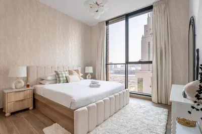 a bedroom with a large white bed and a large window at GuestReady - 1BR l Stylish 10th-Floor Retreat in Dubai