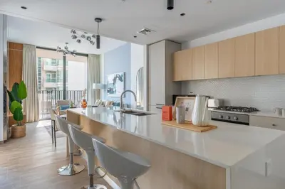 a kitchen with a counter and chairs in a room at GuestReady - 1BR l Stylish 10th-Floor Retreat in Dubai