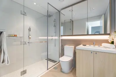 a bathroom with a toilet and a glass shower at GuestReady - 1BR l Stylish 10th-Floor Retreat in Dubai